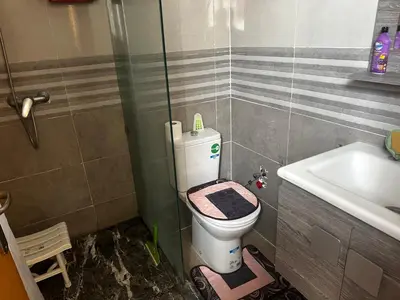 a bathroom with a toilet and a sink at Appartement Familial Spacieux Confort et Tranquillité Assurés in Oulad Akkou