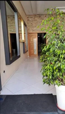 a hallway of a building with a door and a plant at Appartement Familial Spacieux Confort et Tranquillité Assurés in Oulad Akkou