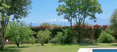 a view of a garden with mountains in the background at Domaine du souffle d Amaia in Had Abdallah Rhiat