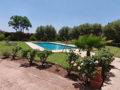 a swimming pool in a garden with trees and plants at Domaine du souffle d Amaia in Had Abdallah Rhiat