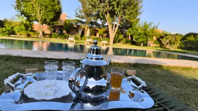 a table with a tea kettle and glasses on it at Domaine du souffle d Amaia in Had Abdallah Rhiat