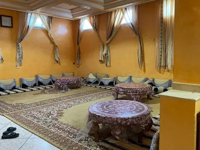 a room with tables and couches in a room at Chez l'habitant tigminnagh in Ouarzazate