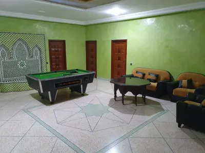 a living room with a pool table and chairs at Chez l'habitant tigminnagh in Ouarzazate