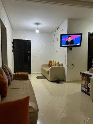 a living room with a couch and a flat screen tv at Bloc A3 AP161 ET4 nakhil lamsala Meknès in Meknès