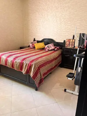 a bedroom with a bed and a chair in it at Bloc A3 AP161 ET4 nakhil lamsala Meknès in Meknès