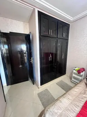 two black cabinets in a room with a bed at Bloc A3 AP161 ET4 nakhil lamsala Meknès in Meknès