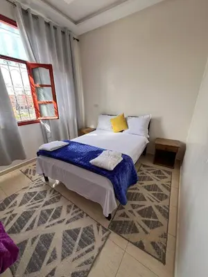 a small bedroom with a bed and a window at Residence Dallas Warzazate in Ouarzazate