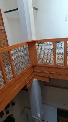 a wooden staircase in a building with a railing at Dar Ayoub in Fès