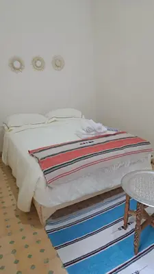 a bed sitting on top of a rug with a table at Dar Ayoub in Fès