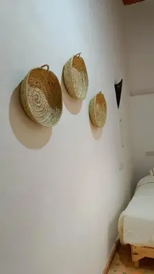 a room with three straw hats hanging on the wall at Dar Ayoub in Fès