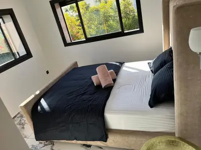 a bed with a brown towel on it in a room at Escape Villa City center pool 3 bedrooms in Oulad Akkou