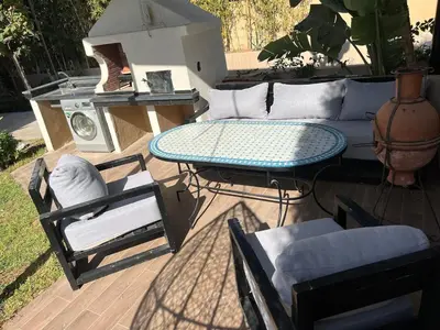 a patio with a couch and a table and chairs at Escape Villa City center pool 3 bedrooms in Oulad Akkou