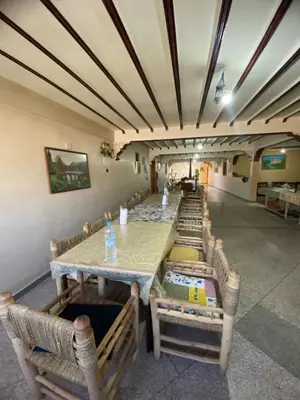 a row of tables and chairs in a room at Maison d'hôtes Moussem des fiançailles in Imilchil