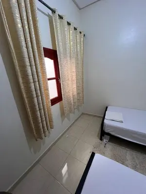 a room with a bed and a window with curtains at Hostel dallas Warzazate in Ouarzazate
