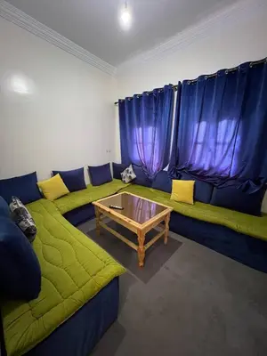 a living room with a green couch and a table at Hostel dallas Warzazate in Ouarzazate