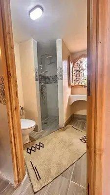 a bathroom with a shower and a toilet and a sink at Serenity Lodge Zagora Guest House Restaurant & Desert Excursions in Zagora