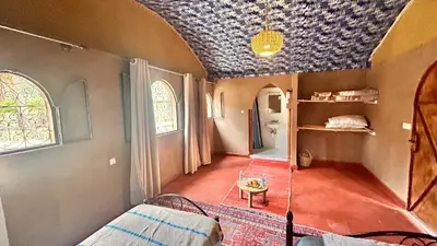 a room with a bed and a room with a ceiling at Serenity Lodge Zagora Guest House Restaurant & Desert Excursions in Zagora