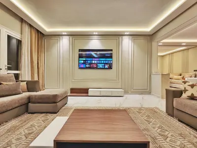 a living room with a couch and a tv at appartement de luxe réservée aux familles in Meknès