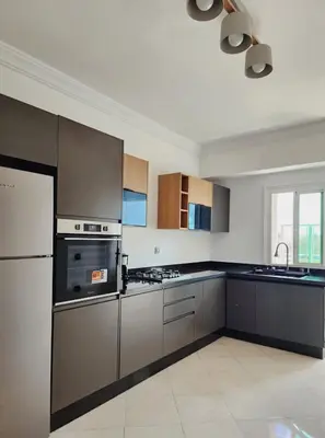 a kitchen with stainless steel appliances and brown cabinets at appartement de luxe réservée aux familles in Meknès