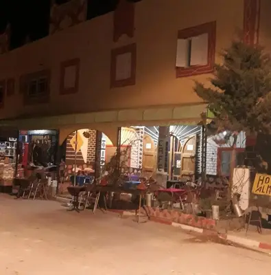 a building with tables and chairs in front of it at almou auberge Imilichil in Imilchil