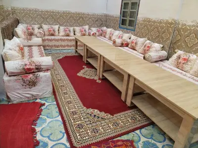 a living room with a long table and a couch at almou auberge Imilichil in Imilchil