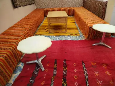 a couch with two chairs and a table on a rug at almou auberge Imilichil in Imilchil