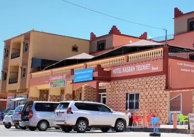 a row of cars parked in front of a brick building at Hotel Kasbah Telouet in Telouet