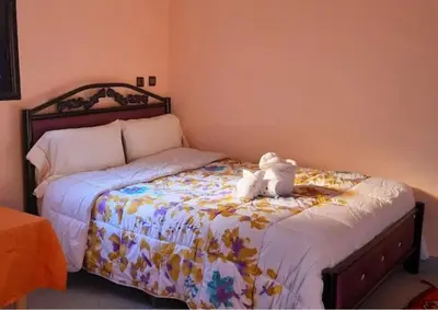 a bedroom with a bed with a stuffed animal on it at Hotel Kasbah Telouet in Telouet