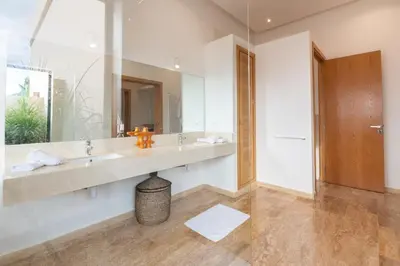 a bathroom with two sinks and a large mirror at Luxury 5-Suite Villa with Heated Pool, Steam Room & Games in Marrakech