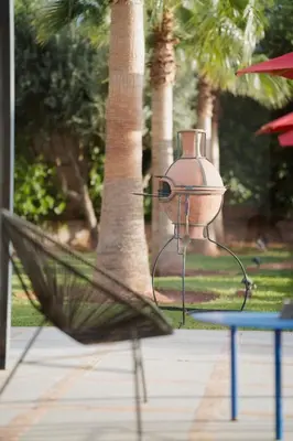 a lamp sitting on a table in front of a tree at Luxury 5-Suite Villa with Heated Pool, Steam Room & Games in Marrakech