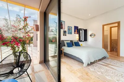 a bedroom with a bed and a balcony at Luxury 5-Suite Villa with Heated Pool, Steam Room & Games in Marrakech