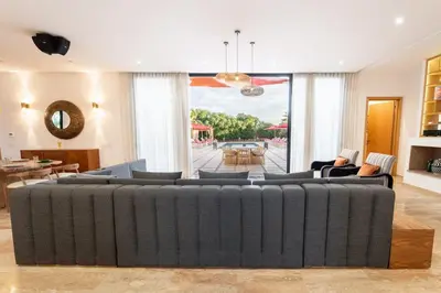 a living room with a large couch in the middle at Luxury 5-Suite Villa with Heated Pool, Steam Room & Games in Marrakech