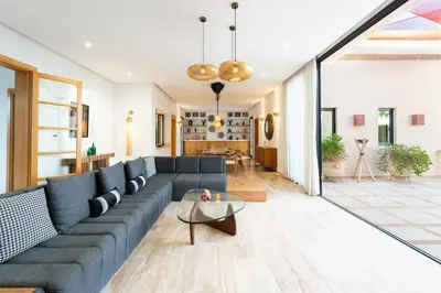a living room with a blue couch and a table at Luxury 5-Suite Villa with Heated Pool, Steam Room & Games in Marrakech