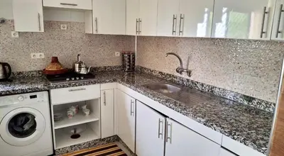 a kitchen with a sink and a washing machine at A new, lively apartment in Oulad Akkou