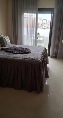 a bed with a blanket on it in a bedroom at A new, lively apartment in Oulad Akkou