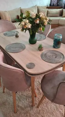 a wooden table with a vase of flowers on it at A new, lively apartment in Oulad Akkou