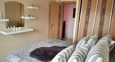a bedroom with a bed with a purple blanket at A new, lively apartment in Oulad Akkou