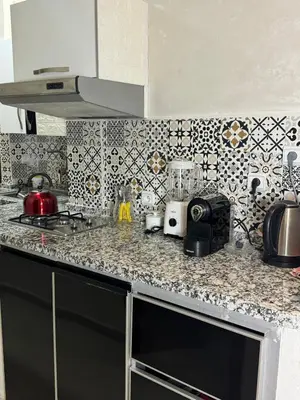 a kitchen with a counter top with a stove at charmant appartement in Fès