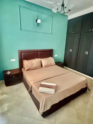a bedroom with a bed and a blue wall at charmant appartement in Fès