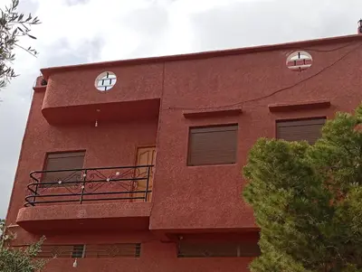 a red building with two windows and a balcony at Appartement de location in Ouaouizaght