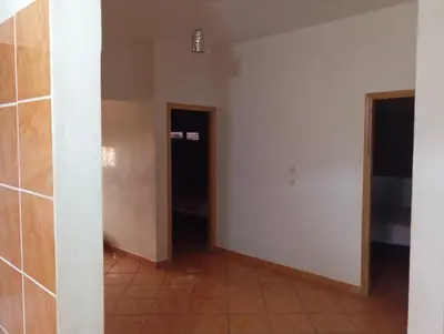 an empty room with two doors and a tile floor at Appartement de location in Ouaouizaght