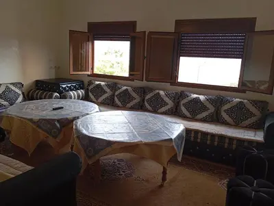 a living room with a couch and two tables at Appartement de location in Ouaouizaght