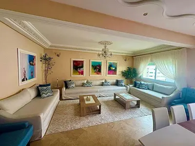 a large living room with couches and a table at apartment champs de cours in Fès