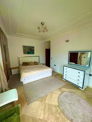 a bedroom with a bed and a dresser and a tv at apartment champs de cours in Fès