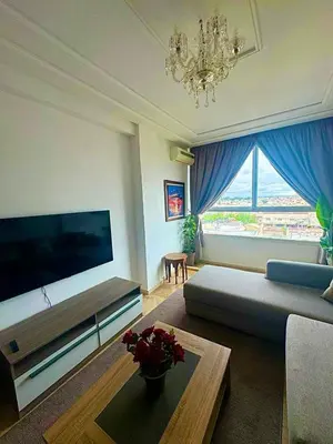 a living room with a couch and a large television at apartment champs de cours in Fès