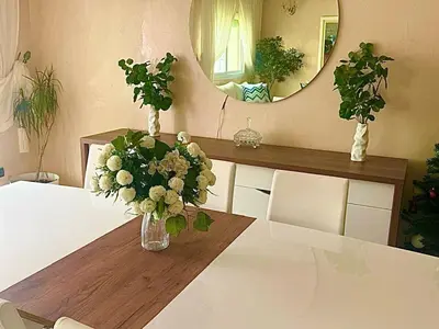 a vase of flowers on a table with a mirror at apartment champs de cours in Fès