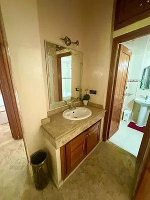 a bathroom with a sink and a mirror at apartment champs de cours in Fès