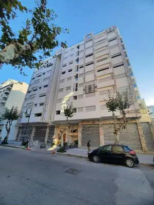 a car parked in front of a large building at Tanger Apt Near Train & Mall in Oulad Akkou