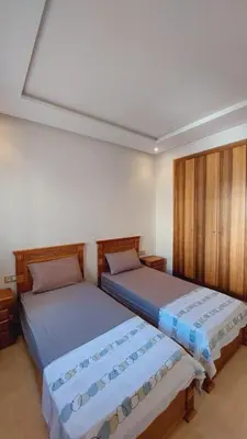 two beds sitting next to each other in a room at Tanger Apt Near Train & Mall in Oulad Akkou