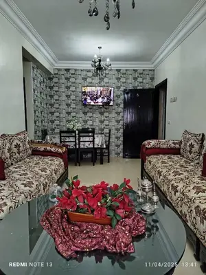 a living room with couches and a table with flowers on it at appartement martil in Oulad Akkou